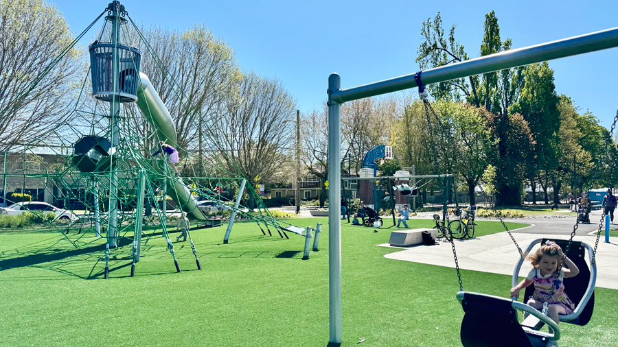 girl on face-to-face swing on the playground in Seattle on a sunny day