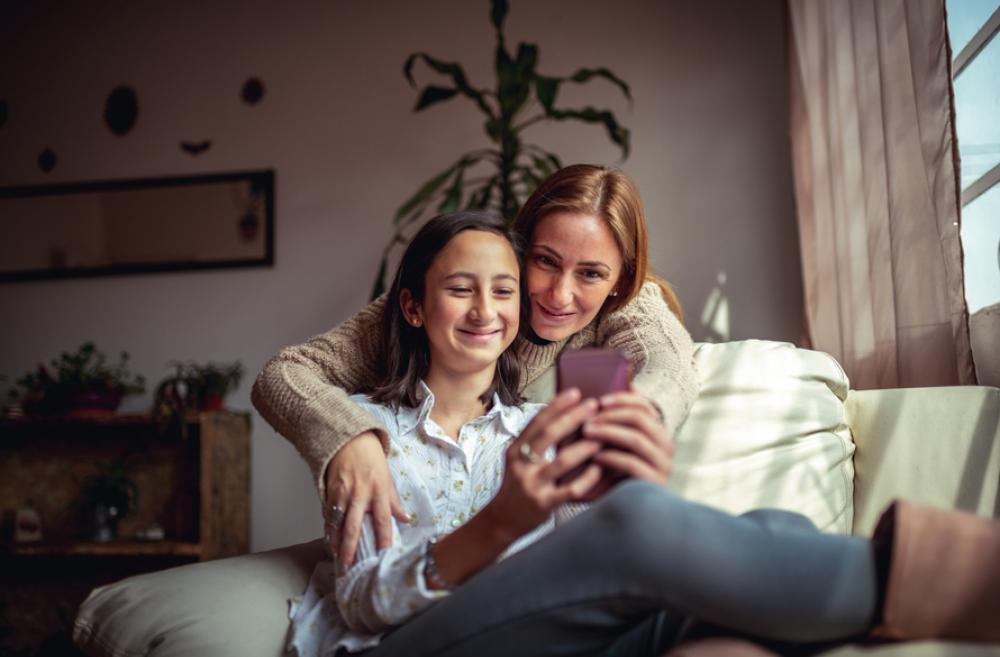 mother and daughter looking at a smartphone together