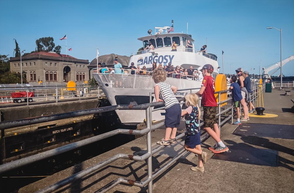 Kids at the Ballard Locks, a top tourist attraction in Seattle, watch an Argosy boat pass through the locks from Lake Washington to Puget Sound
