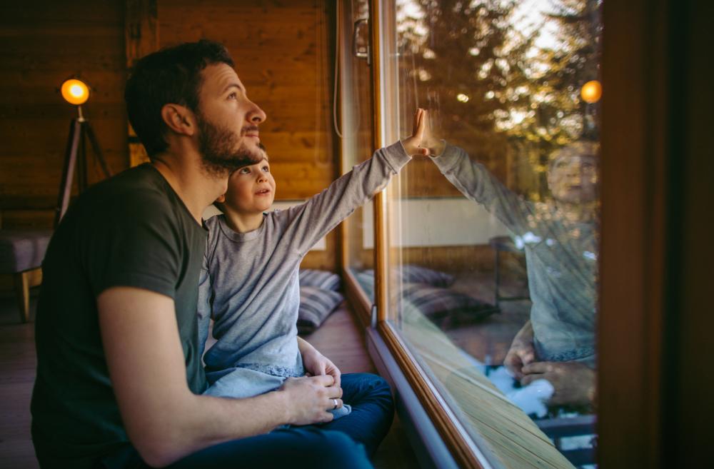 father and son sitting on a window seat in a rustic cabin