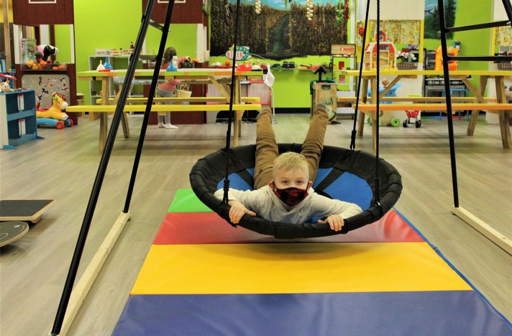A boy plays in a ring swing at Kaleidoscope Family Play Gym in Puyallup, among the Seattle area's indoor play spaces for kids ideal for rainy-day play