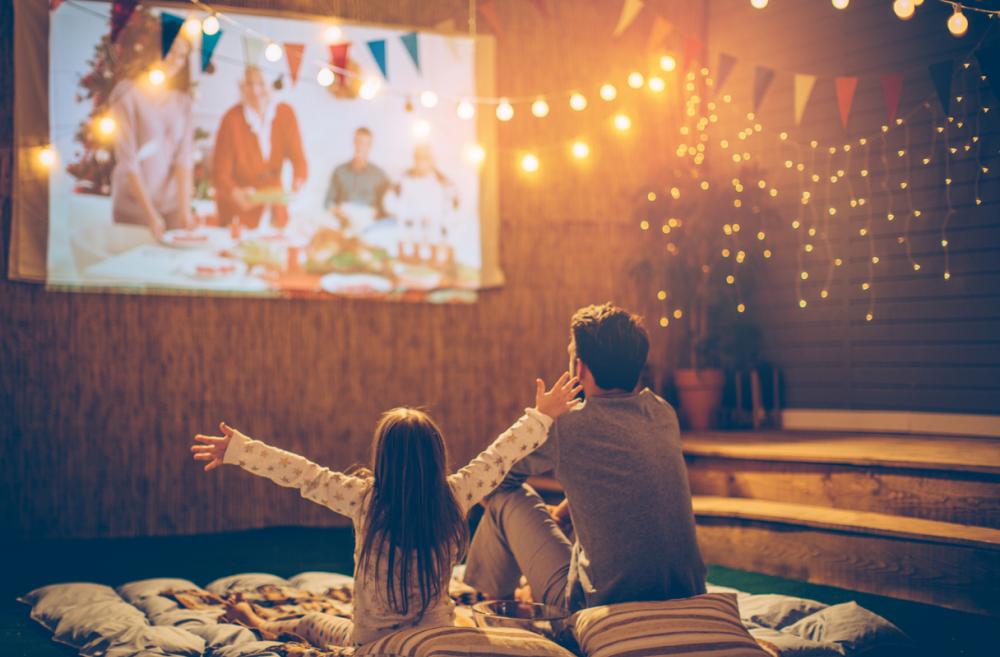 Little girl and dad watching a movie outside