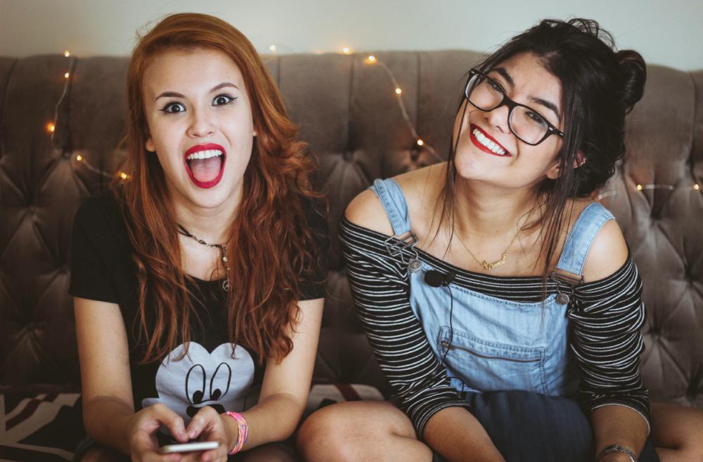 Teenagers sitting on a couch smiling