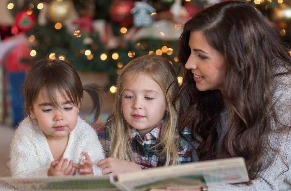 Mom-reading-to-kids-by-Christmas-tree