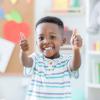 Boy holding two thumbs up at preschool