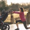 Mom young child in running stroller doing a lunge for exercise on best paths and trails for kids and strollers around Seattle and the Eastside