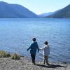 Brothers in jackets stand at the shore of Lake Crescent on Washington's Olympic Peninsula a getaway spot for Seattle-area families
