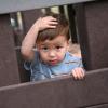 toddler holding his head on a play structure
