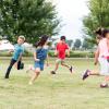 kids running in a circle out in a grassy field
