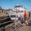 Kids at the Ballard Locks, a top tourist attraction in Seattle, watch an Argosy boat pass through the locks from Lake Washington to Puget Sound