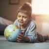 little boy looking at a globe