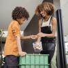 African american young woman and her younger brother making compost from leftovers.