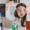 Girl filling test tube wearing goggles during an easy science experiment for kids