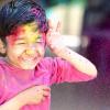Boy in colorful powder from Holi Festival