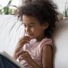 Kid-reading-a-tablet-on-sofa
