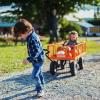 Boy pulling wagon with young sibling in it picking out their pumpkins at a seattle-area pumpkin patch in early fall 2022