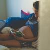 Pregnant woman sitting in a bed reading "Goodnight Moon"