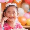 Smiling girl with birthday balloons behind her