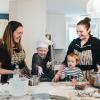 Family cooking together with young child making mess with flour