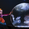 Young girl held up by her father touching the Jelly Globe