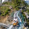 A dad and child ride a coaster car down the side of a mountain at the newly opened Leavenworth Adventure Park