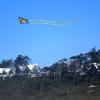 A kite flies above a row of houses on the bluff a Seabrook, vacation spot for Seattle families