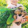 Young girl holding root veggies from a seattle CSA