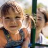 Little girl smiling and climbing on a play structure 