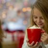 two young girls drinking hot chocolate from a big red mug 