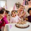 Little girl blowing out birthday candles at birthday party