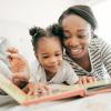 Mom and daughter reading a book about Black history