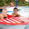 Two kids on a red and white striped boat at Water Waves Theme and Water Park in Federal Way near Seattle