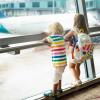 two kids looking out a window at an airplane SEA airport
