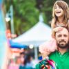 dad with daughter on shoulders at a spring family festival
