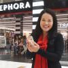 woman holding up a free gift from Sephora on her birthday
