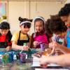 kids sitting around a table engaged in an art project