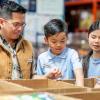 family volunteering and putting food into boxes at a food distribution center