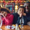 A family enjoys eating a meal out at a restaurant on Christmas Day.