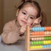 Girl learning how to count on abacus toy