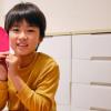 A boy holds a red heart while making crafts for Valentine's Day.