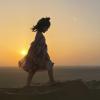 young girl walking on sand dunes