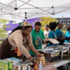 Community cooking event under a tent with food in Seattle