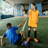 soccer player helping another player to their feet