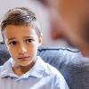 worried little boy talking to adult