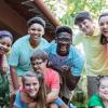 Group of teens and camp staff smiling together outdoors at camp
