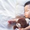 Newborn baby sleeping with teddy bear