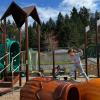 girl jumping across climbers at Shoreview Park's baseball playground