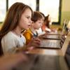 young girl studying on laptop in classroom