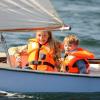 Two kids sailing in small vessel