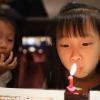 little girl blowing a birthday candle